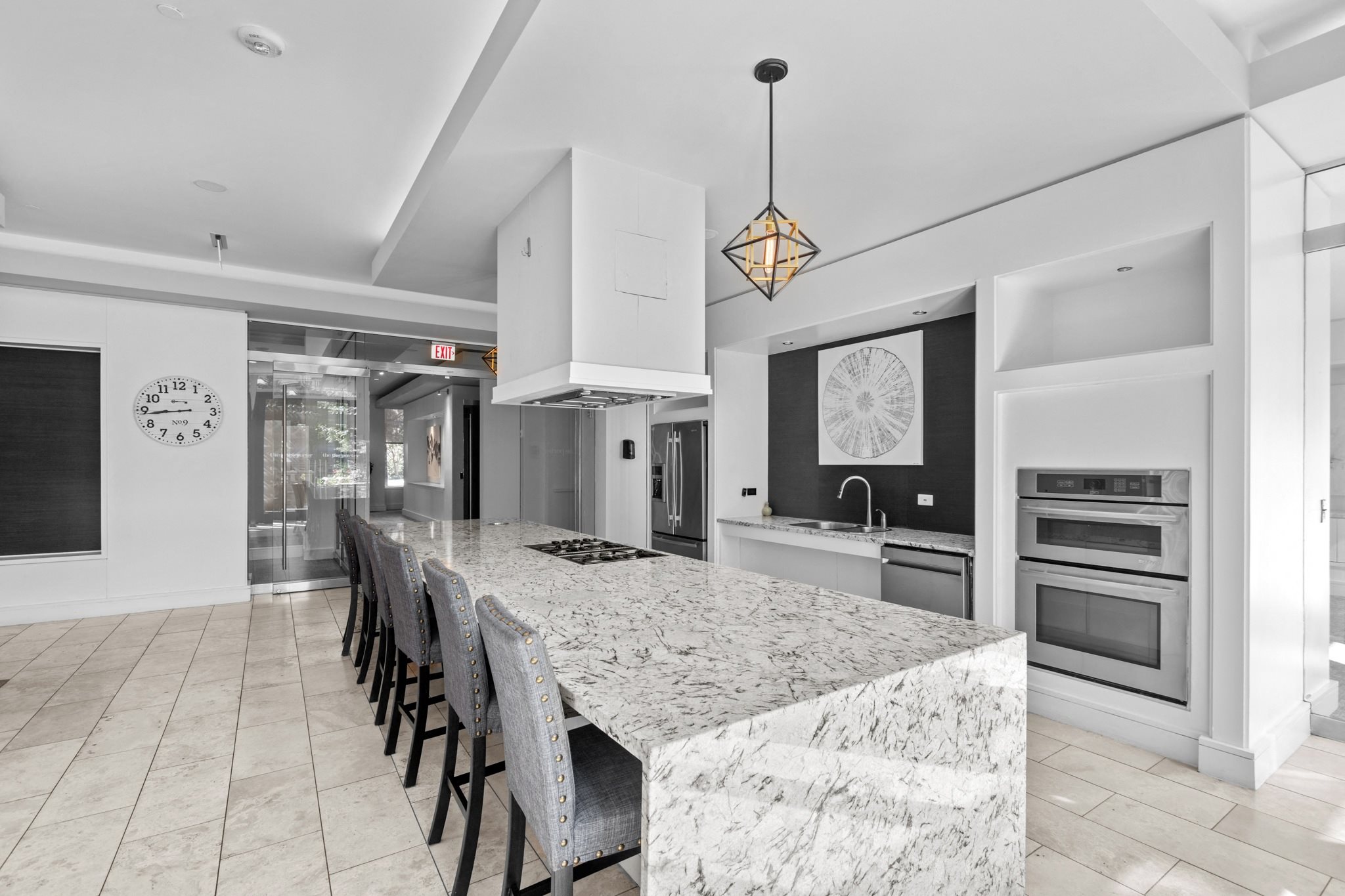 the kitchen has a large island with granite countertops and a long table with chairs